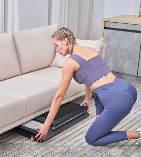Movaped P1 treadmill stored under sofa for flexible space saving storage